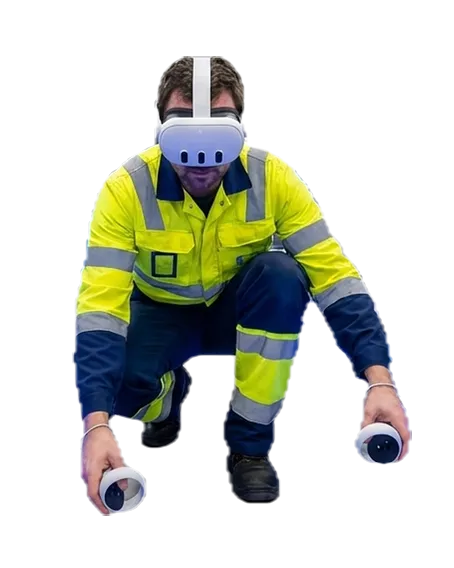 A Rysax field technician in high visibility clothing, crouching in a virtual reality headset with a controller in each hand, reaching towards the floor.